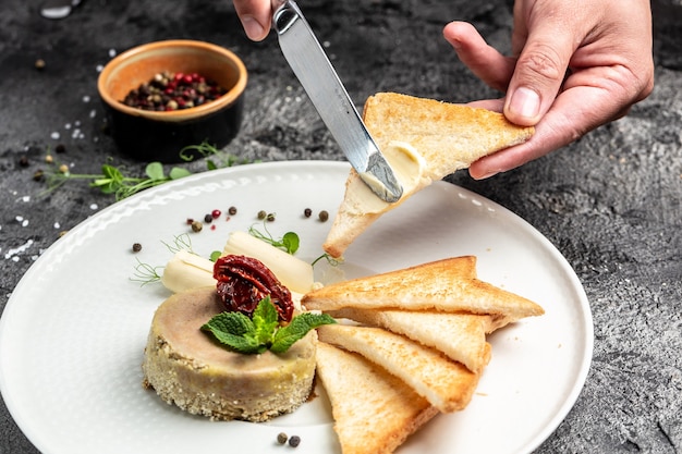 Coronilla. manos masculinas engrasa pan tostado con mantequilla y paté