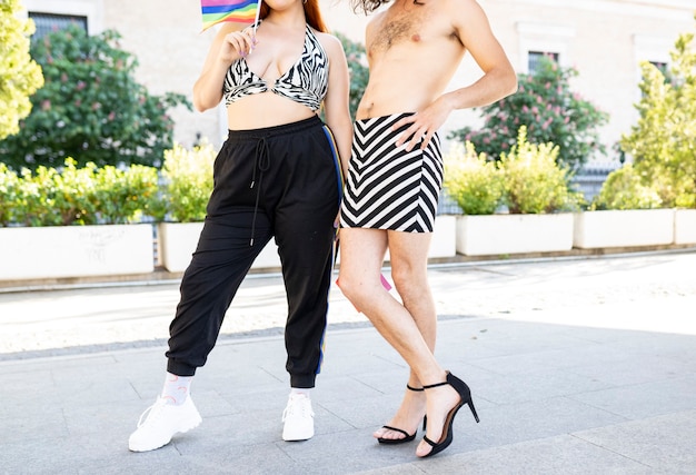 Corpo de mulher com roupa casual e corpo de homem com saia e sem t-shirt com bandeira lgbt