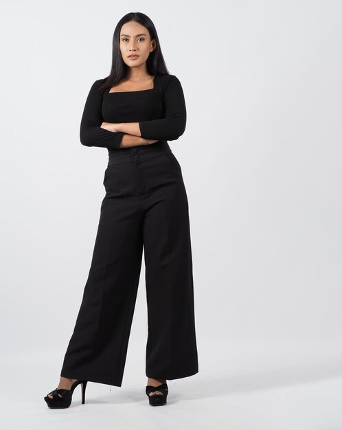 Corpo inteiro de mulher asiática. mulher tailandesa em um estilo chique moderno fica em estúdio branco com pose elegante e confiante. modelo de elenco de atriz coadjuvante. mulher asiática fullbody pose na frente da câmera.