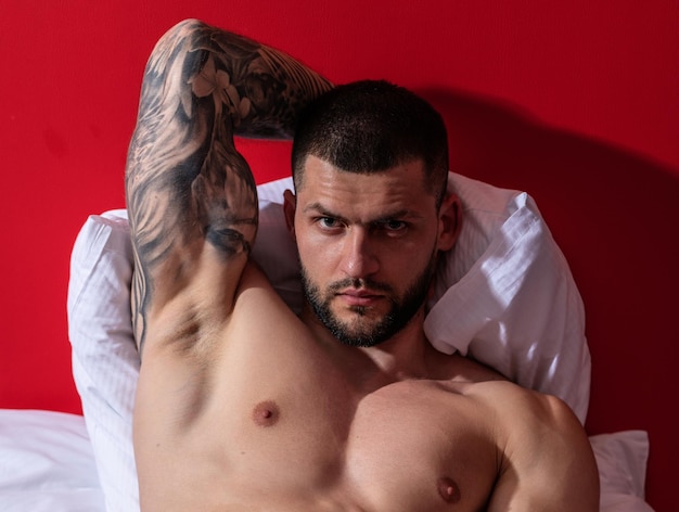 Corpo musculoso gay sedutor de homem sexy na cama cara forte e brutal homem sexy torso nu musculoso