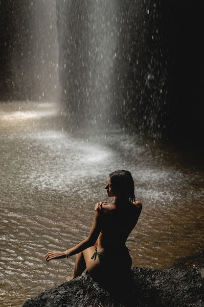 Corpo perfeito. Mulher jovem e atraente virando a cabeça e tocando o ombro enquanto fotografava para uma revista de moda