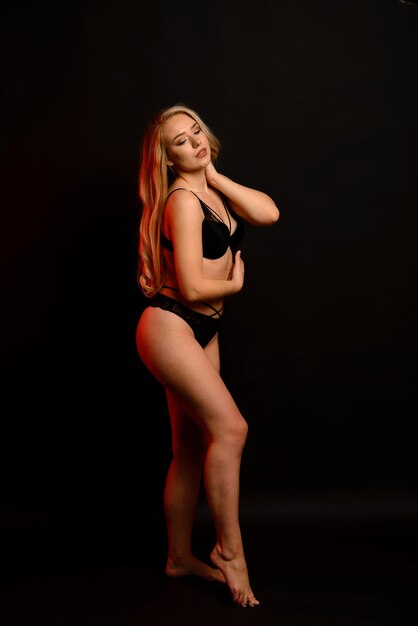 Corpo positivo. Linda loira de cueca, estúdio preto e azul, atraente plus size