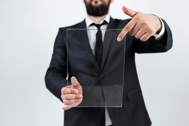 Corporación masculina sosteniendo y apuntando a un vidrio transparente y mostrando un anuncio importante