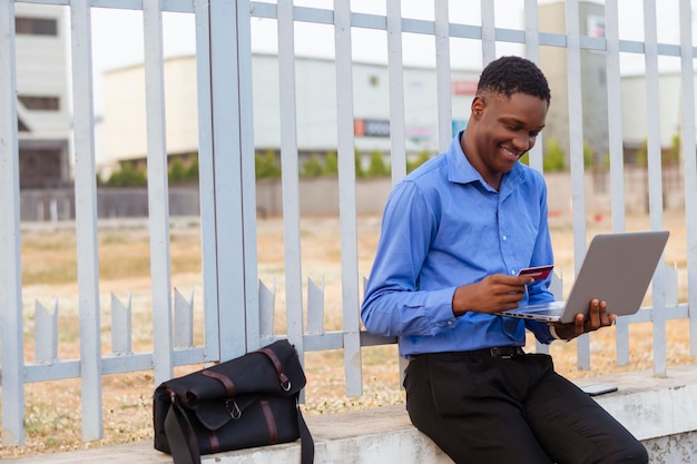 Corporate afrikanischen Geschäftsmann mit moderner Technologie für Online-Shopping