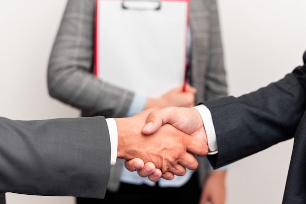 Corporate Businessmen Handshake Indoors.Zwei Personen professionell gut gekleidet gestikulieren Zusammengehörigkeit.Arbeitskollegen Partner unterzeichnen Vereinbarung zum Vertrag