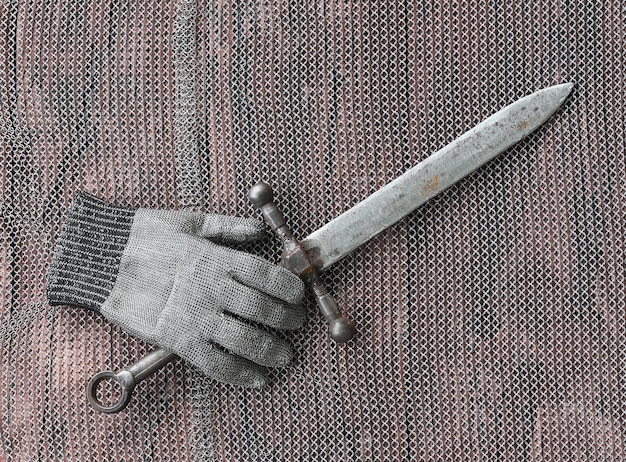 correa de cadena y espada en una mesa de madera