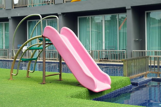 Corrediça de plástico rosa para crianças na piscina