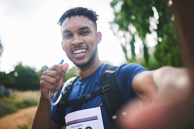 Corredor, atleta y al aire libre en una carrera de selfies o entusiasmado por el triatlón, el senderismo o la aventura en el bosque. Joven africano feliz y fotografía para la foto de perfil de la memoria o una publicación para la red social.