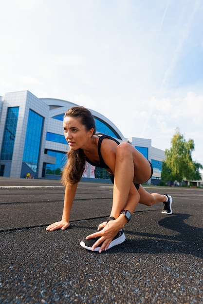 Foto corredor de atleta corriendo en pista de atletismo entrenando su cardio. mujer para correr para la carrera de competición en el estadio al aire libre de verano.