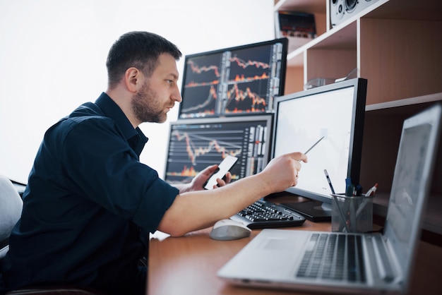 Foto el corredor de bolsa en camisa está trabajando en una sala de monitoreo con pantallas. gráfico de la bolsa de comercio forex finanzas. empresarios que negocian acciones en línea