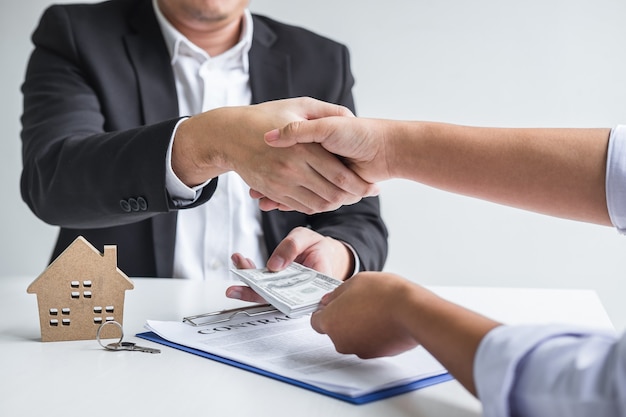 Foto corredor y cliente dándose la mano después de firmar el contrato de alquiler