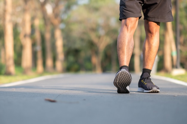 Corredor corriendo en la carretera exterior. atleta trotar y hacer ejercicio en el sendero