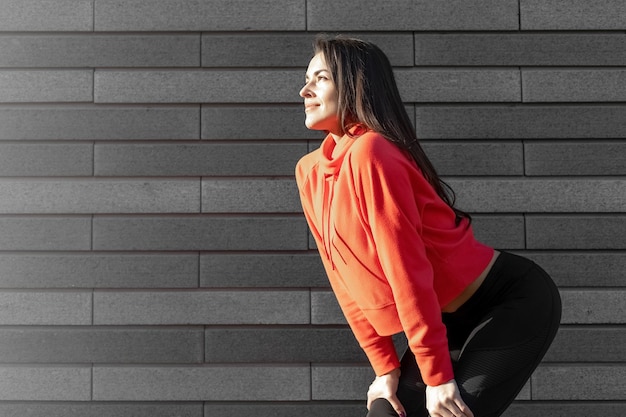 Corredor de atleta feminina descansando treino ao ar livre no corredor de ar fresco faz uma pausa usando roupas esportivas