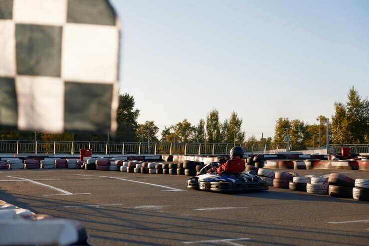Foto corredor de gocart se movendo rápido na pista de corrida de motor ao ar livre