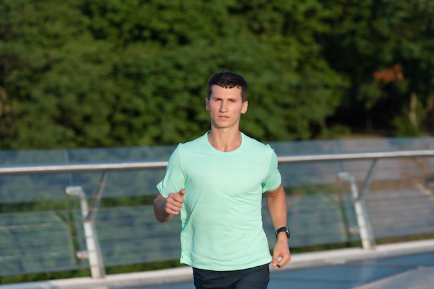 Corredor de homem desportivo correndo em roupas esportivas ao ar livre