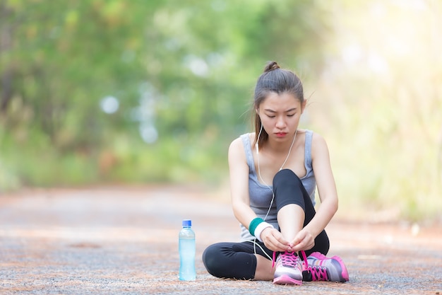 Corredor de mulher Ásia jogging exercício sozinho para perder peso gordo amarrar cadarços