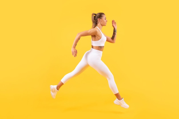 Corredor de deporte mujer corriendo sobre fondo amarillo