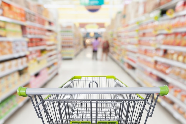 Foto corredor do supermercado com carrinho de compras vazio no conceito de negócio de varejo de supermercado