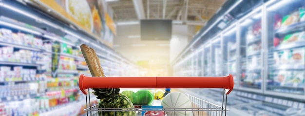 Foto corredor do supermercado com ilustração 3d do carrinho de compras vermelho vazio