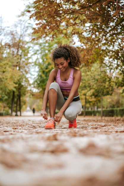 Corredor femenino de la aptitud del deporte que consigue listo para activar al aire libre en parque.