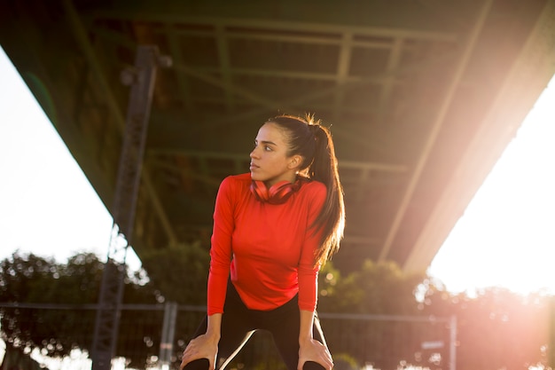 Corredor femenino atractivo tomando descanso después de correr al aire libre