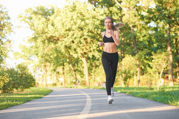 Corredor femenino corriendo en el bosque