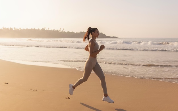 Foto corredor feminino correndo durante treino ao ar livre na praia