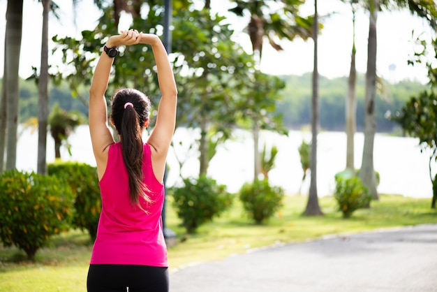 Foto corredor de fitness mujer estirando el brazo antes de correr en el parque