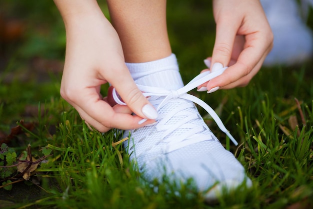 Corredor de hermosa mujer atarse los cordones de los zapatos