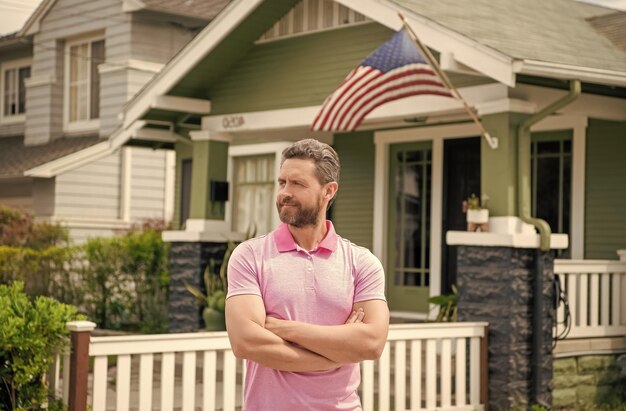 Corredor de hombre barbudo vendiendo o alquilando casa con bandera americana