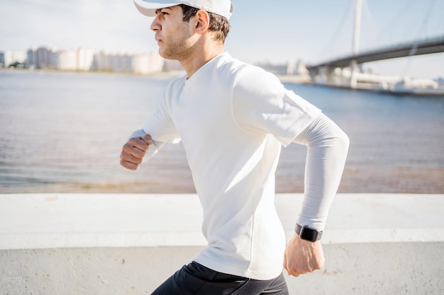 Corredor joven corriendo fuera de entrenamiento activo reloj deportivo inteligente a mano