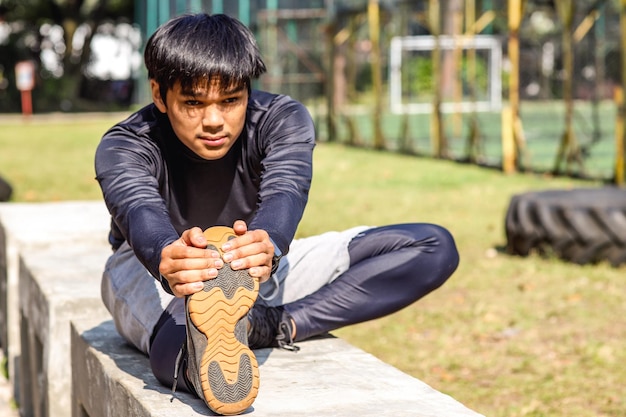 Corredor de joven fitness hombre estirando las piernas antes de ejecutar