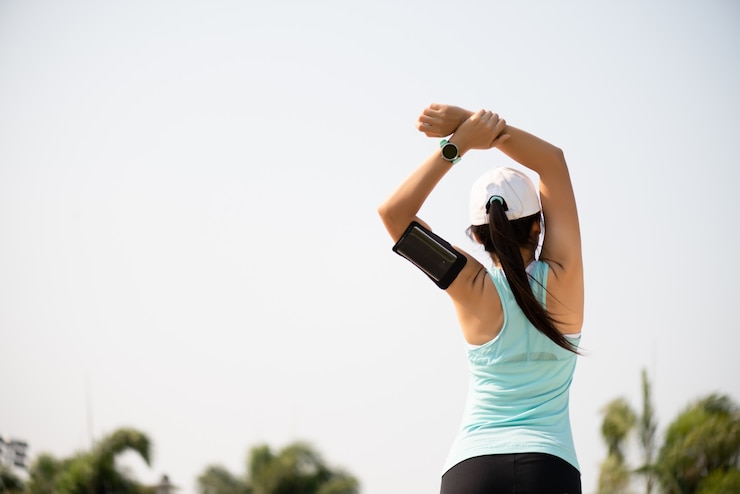 Foto corredor joven fitness mujer estirando el brazo antes de correr en el parque.