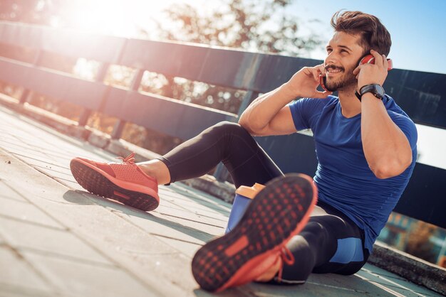 Corredor masculino fazendo exercícios de alongamento