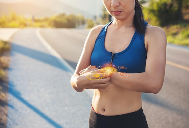 Corredor de mujer deportiva que usa un reloj inteligente que verifica el rendimiento o el seguimiento del pulso de la frecuencia cardíaca Deporte y fitness femenino al aire libre con el concepto de icono de gadget de tecnología