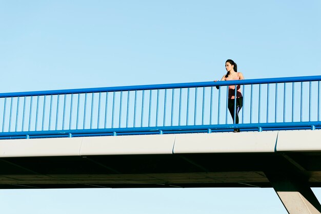 Corredor de mujer joven fitness estirando las piernas después de correr. Concepto de deporte.