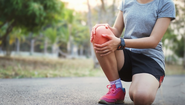 Foto corredor mujer con lesión de rodilla y dolor.