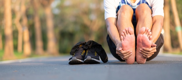 Corredor tendo pés único dor e problema após a corrida e exercício fora da manhã