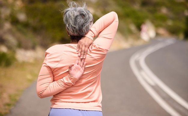 Corredora de la tercera edad que se estira hacia atrás y entrena en la naturaleza de la calle y hace ejercicio para el bienestar en la jubilación