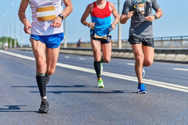 Corredores de maratona na estrada da cidade. competição em execução. corrida de rua ao ar livre