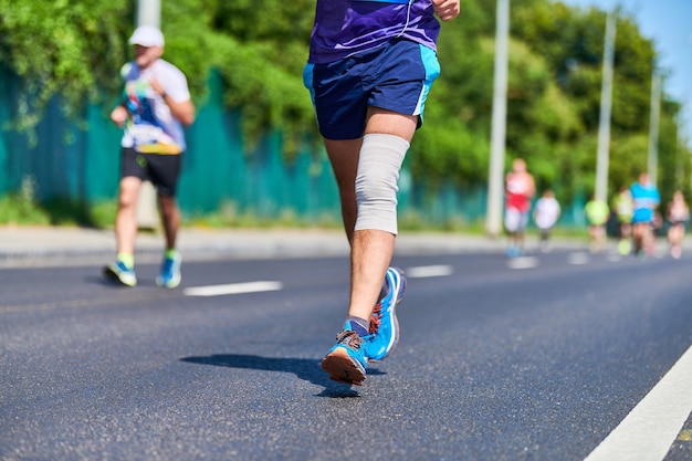 Corredores de maratón en la carretera de la ciudad