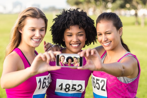 Corredores que apoiam a maratona do câncer de mama e tomam Selfies