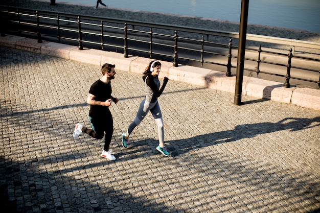 Corredores saudáveis ​​correndo na cidade com fundo de paisagem urbana