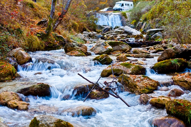 Córrego da montanha na velha floresta no outono