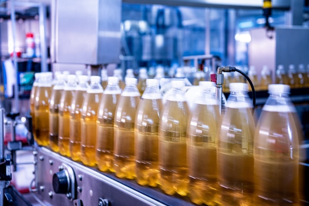 Correia transportadora com garrafas para suco ou água em uma moderna fábrica de bebidas