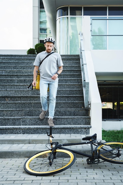 Foto correio de entrega expresso com saco isolado descendo as escadas