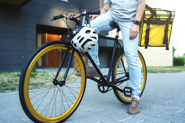 Correio de entrega expresso com saco isolado sentado na bicicleta