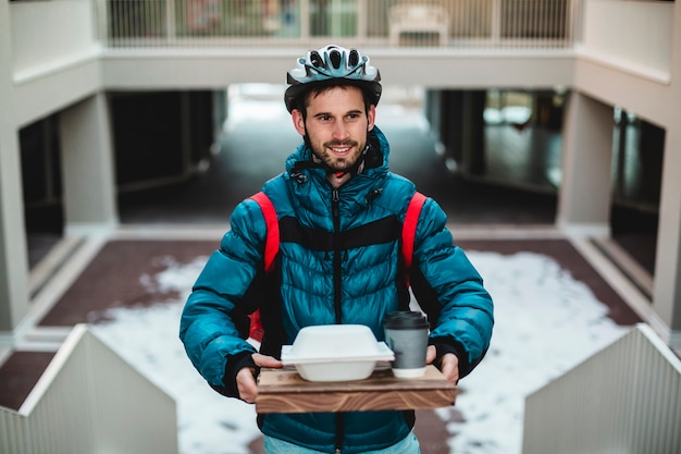 Correio em casa com sanduíches de pizza e bebidas. entrega em casa de bicicleta.