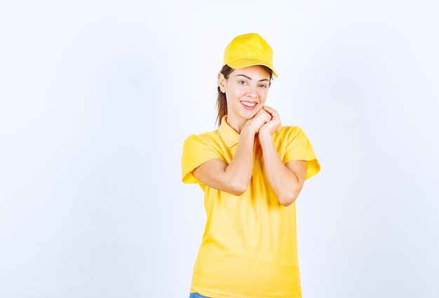 Correio feminino em uniforme amarelo, dando poses de paquera.