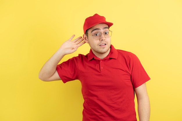 correio masculino em uniforme vermelho em pé sobre o amarelo.